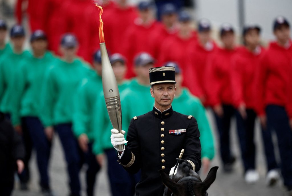 Olympic flame arrives in Paris, at the center of Bastille Day parade